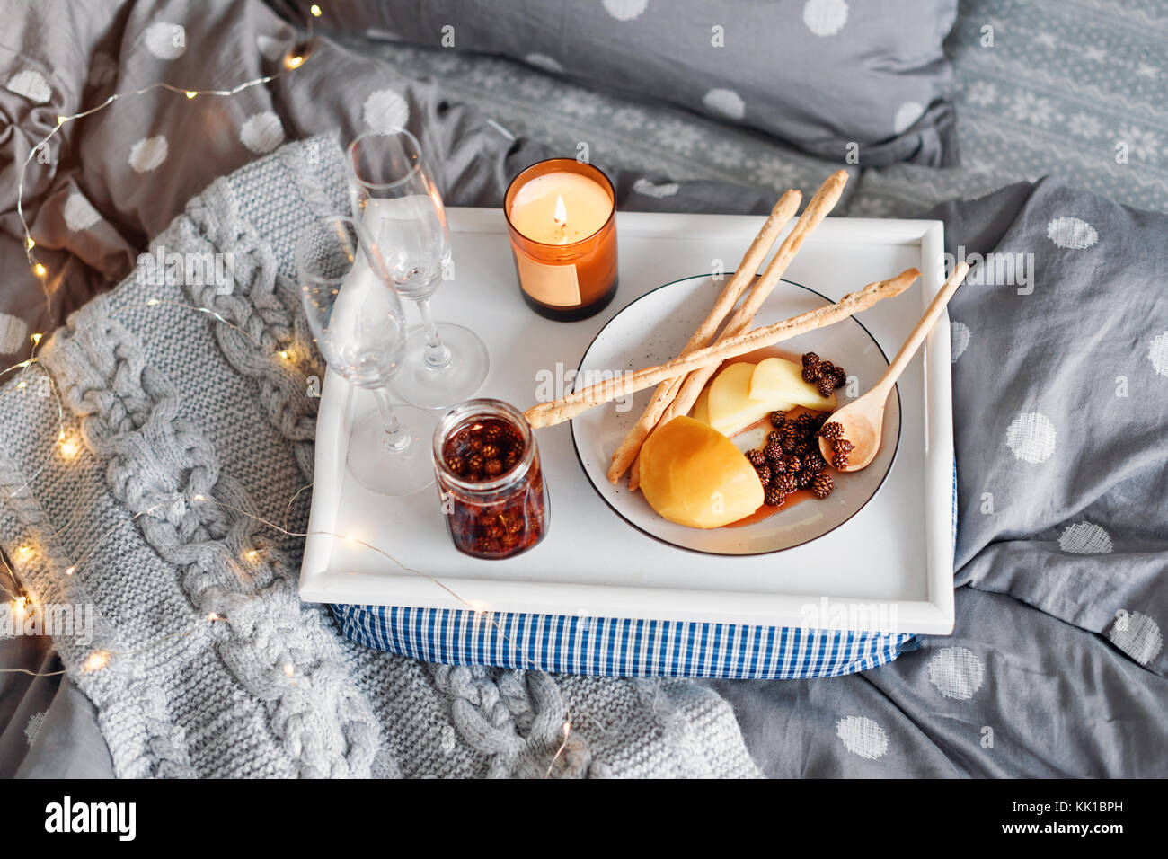 Petit-déjeuner au lit, un plateau de fromage, grissini, confiture de jeunes  cônes de sapin, champagne et une bougie. Le matin de Noël. De miel. Tôt le  matin, à l'h Photo Stock -
