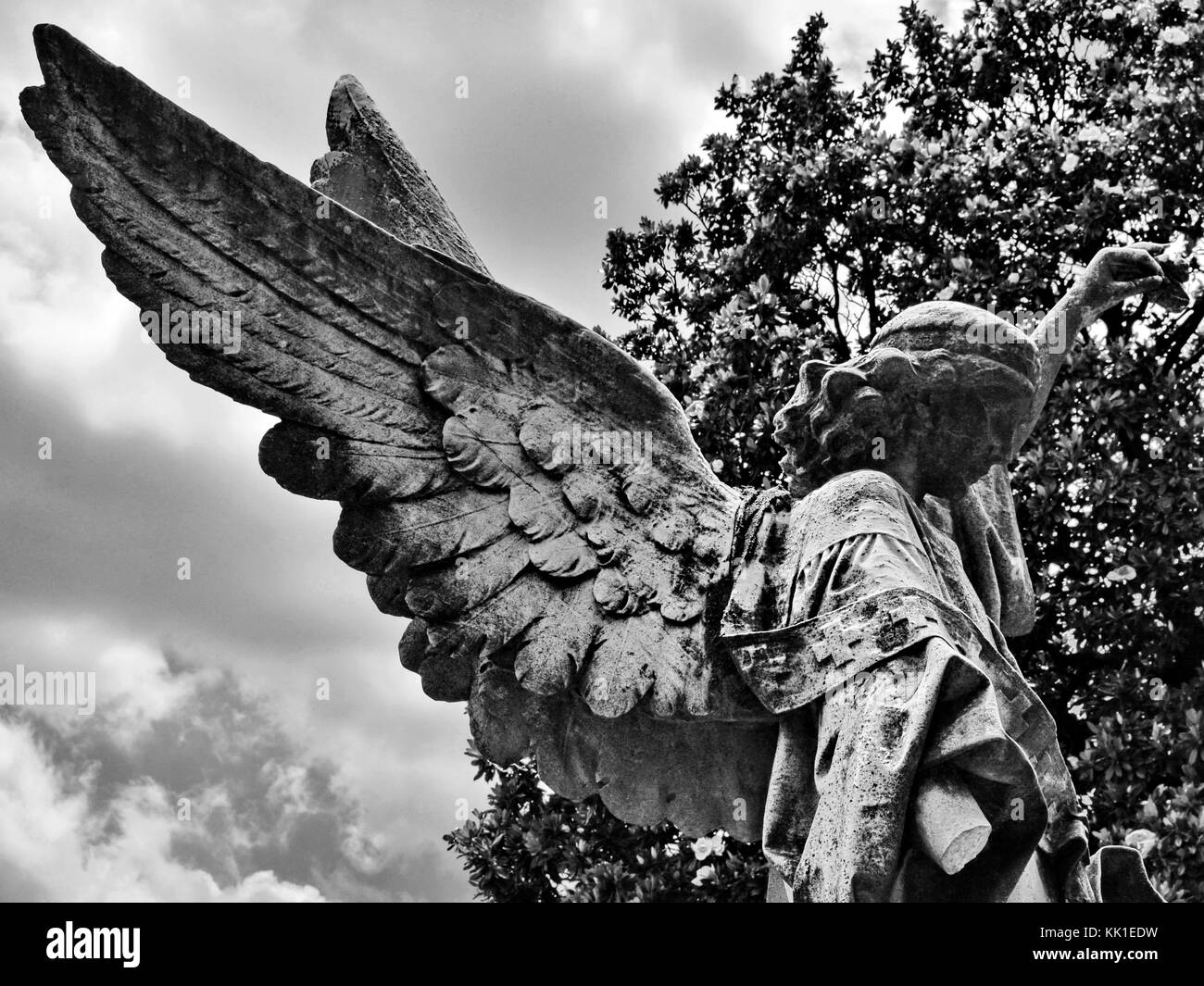 Cet ange s'agenouille au sommet d'un mémorial à l'épitaphe "Il est semé en faiblesse, il est relevé au pouvoir." Banque D'Images Cet ange s'agenouille au sommet d'un mémorial à l'épitaphe "Il est semé en faiblesse, il est relevé au pouvoir." Banque D'Images
