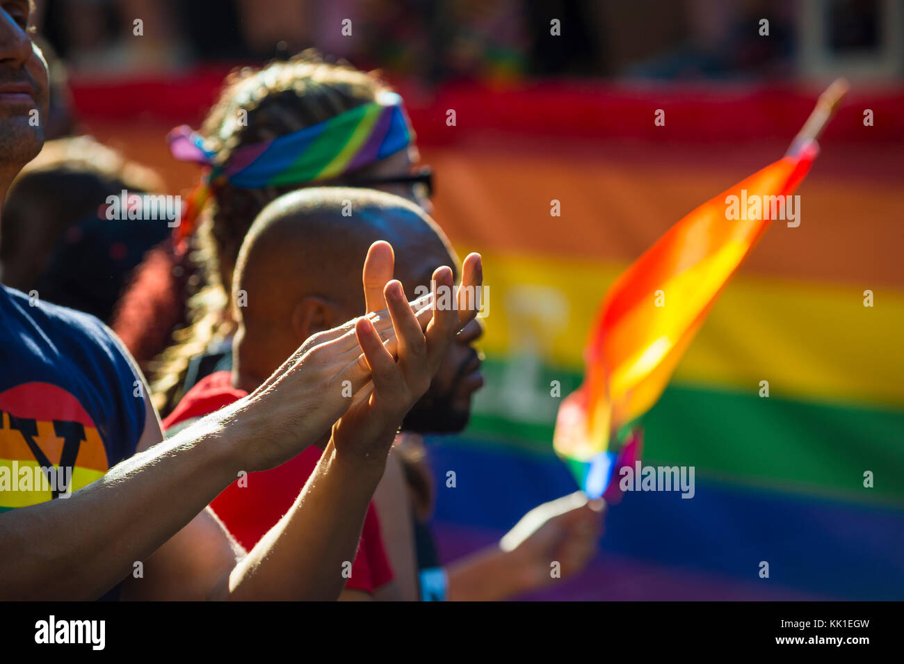 New York - 25 juin 2017 : partisans applaudissent et drapeaux arc-en-ciel de l'onde en marge de la marche des fiertés annuelle qui passe par Greenwich village Banque D'Images