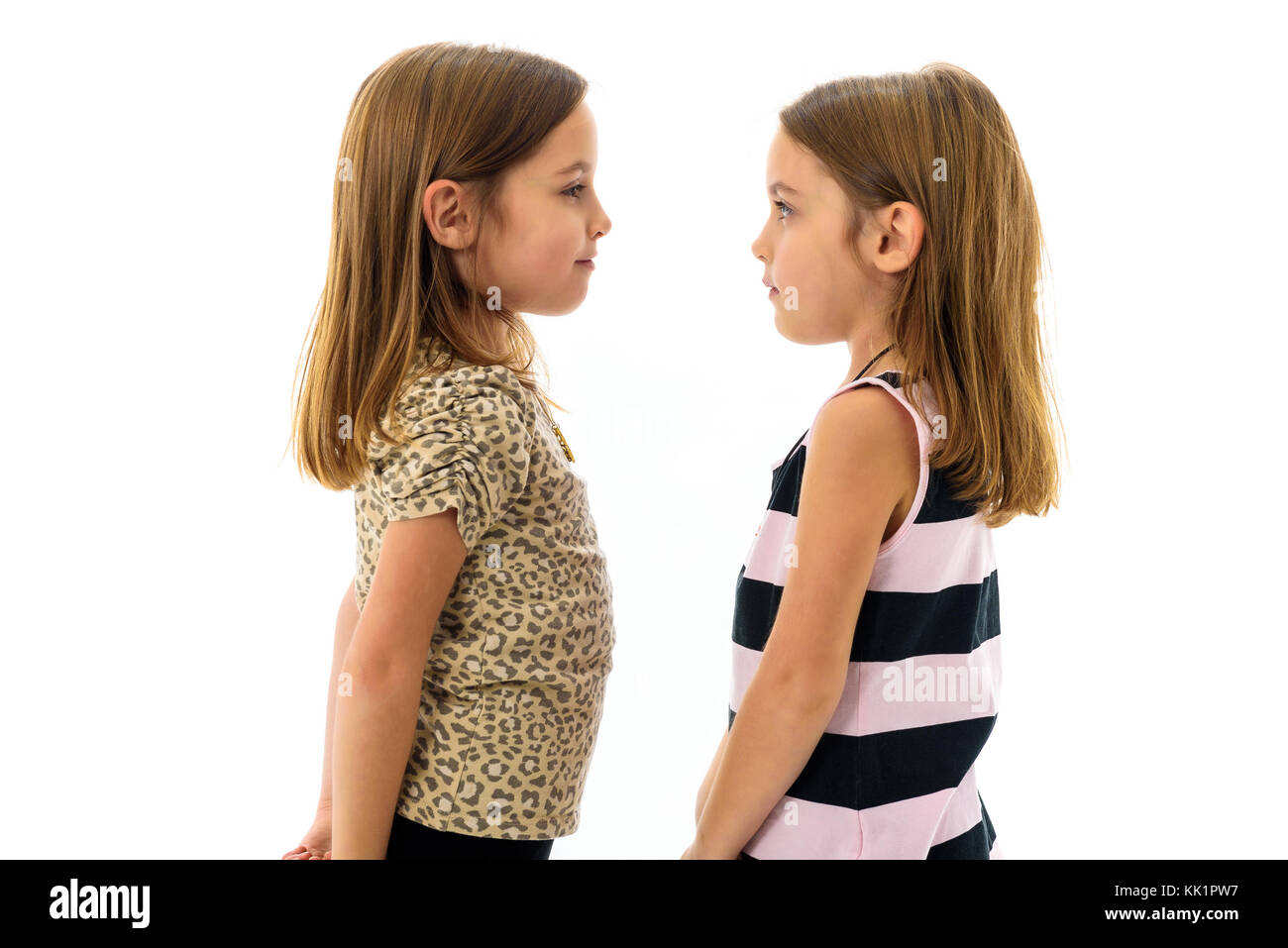 Les filles sont jumeaux identiques à l'un l'autre et souriant. concept de la famille et l'amour fraternels. profil Vue latérale des sœurs à la recherche à l'autre. Banque D'Images