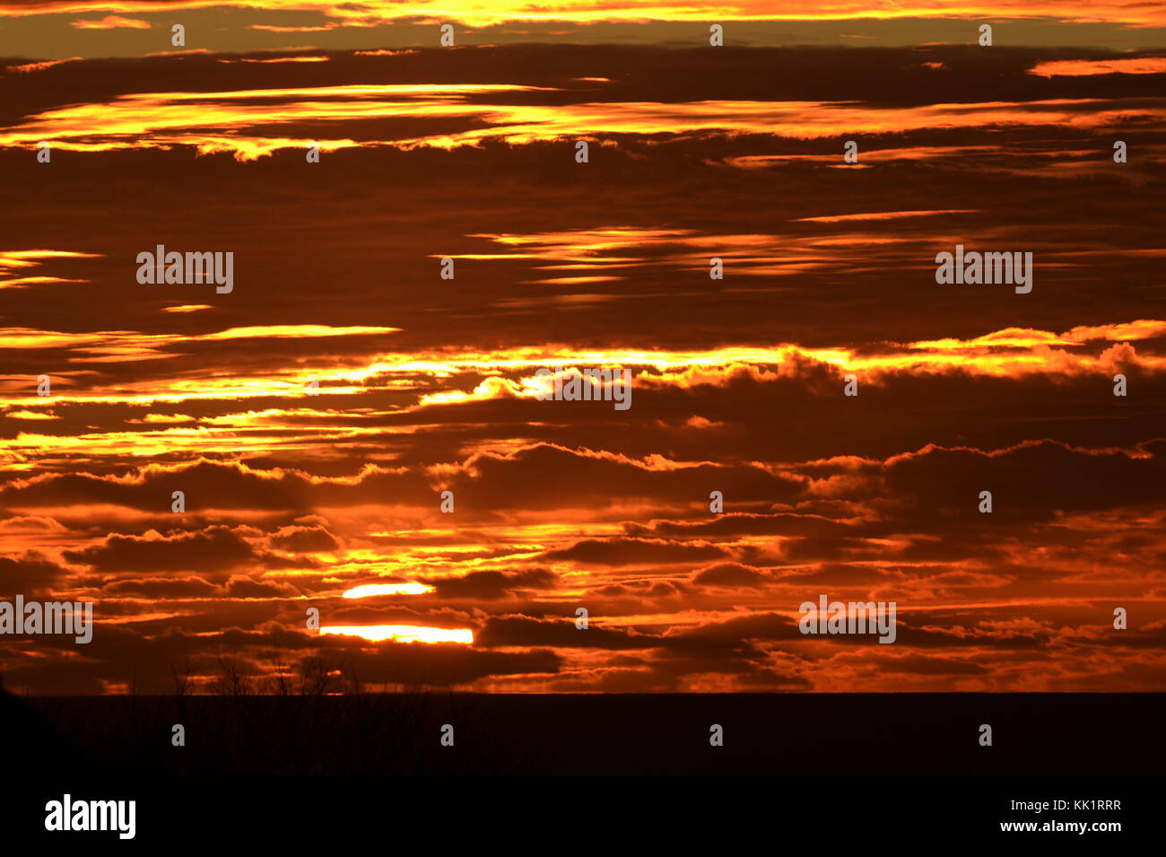 Grande terrasse bien sombre dans la mer partiellement obscurcis par des nuages orange Banque D'Images
