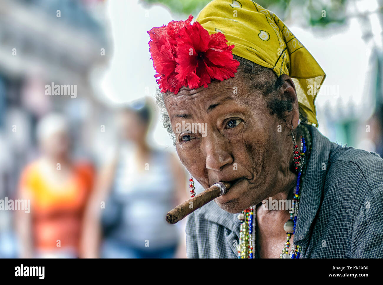 Une femme habillée excentriquement avec un cigare dans la bouche attend que les conseils soient photographiés par les touristes dans la vieille Havane, Cuba Banque D'Images