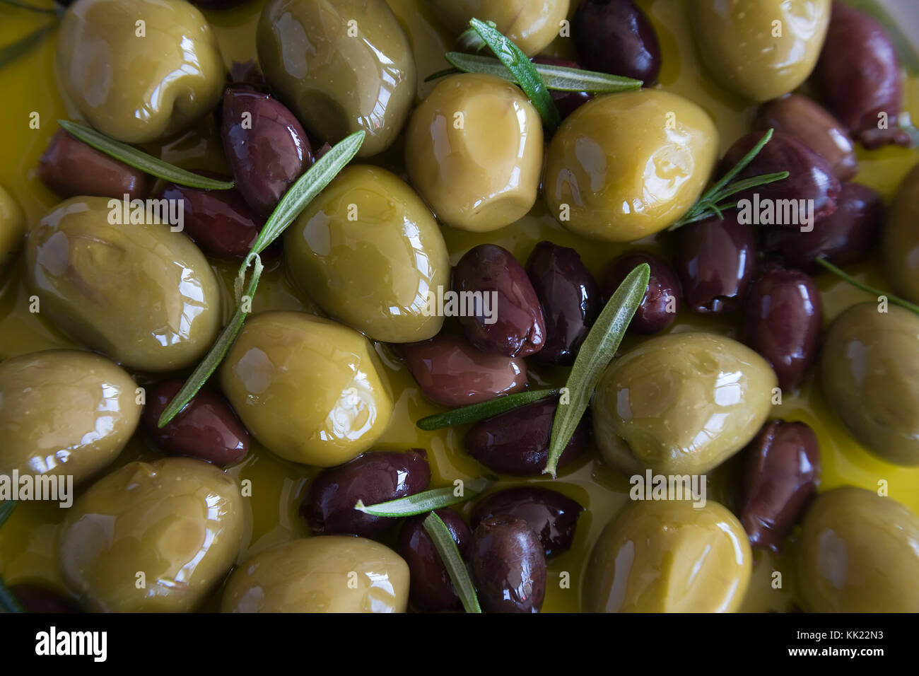 Olives noires et vertes dans l'huile d'olive parfumé aux herbes Banque D'Images