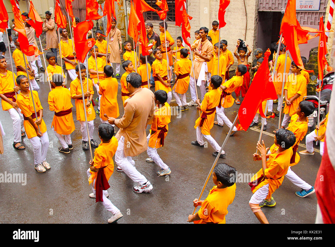 Groupe de petits garçons, dansant avec des drapeaux, pendant la procession Ganapti, festival Ganapati, Pune Banque D'Images