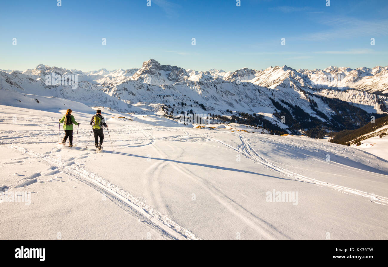 Deux randonneurs en raquettes au coucher du soleil en hiver alpin montagnes. Bavière, Allemagne. Banque D'Images
