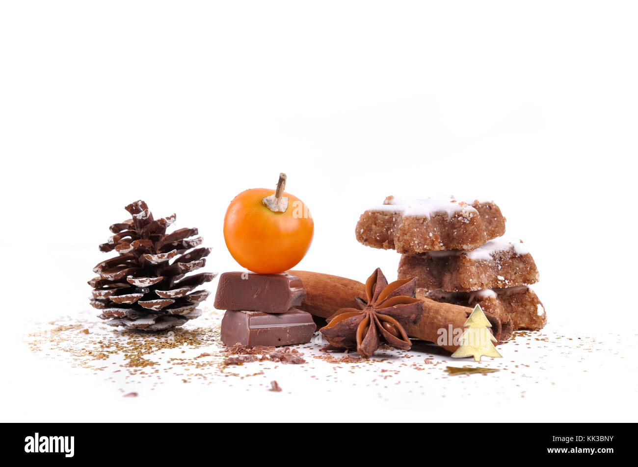 Fruits de physalis sur morceau de chocolat avec les cookies dans la cannelle et anis étoilé en confettis d'or sur fond blanc Banque D'Images