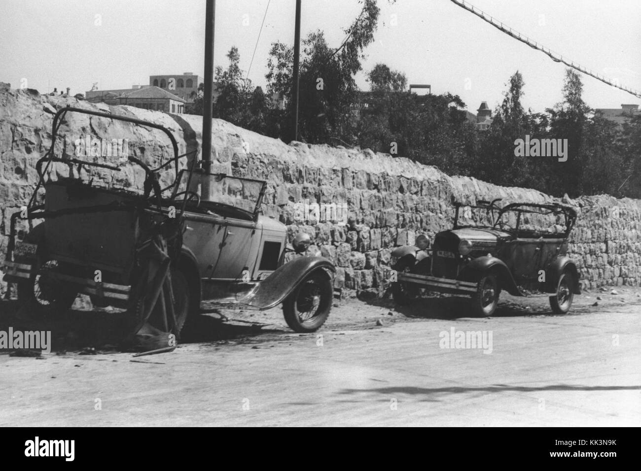 Cette photographie montre deux voitures appartenant à des résidents juifs du quartier Mamilla de Jérusalem, incendiées lors d'émeutes anti-juives dans les années 1920, reflétant les tensions de l'époque. Banque D'Images