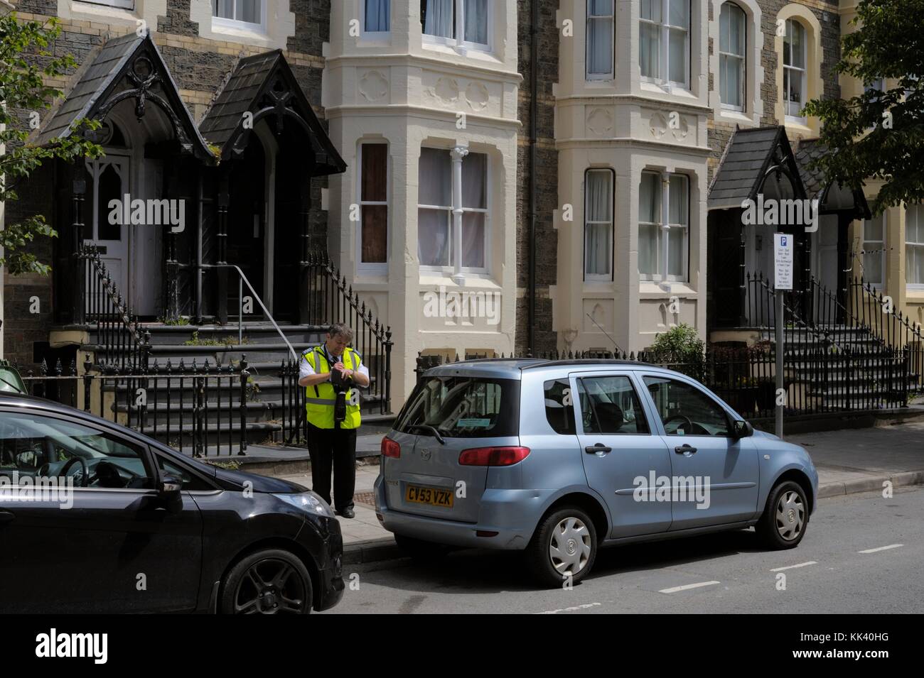 L'enregistrement des gardes de circulation stationnement en infraction, Aberystwyth, Pays de Galles, Royaume-Uni Banque D'Images
