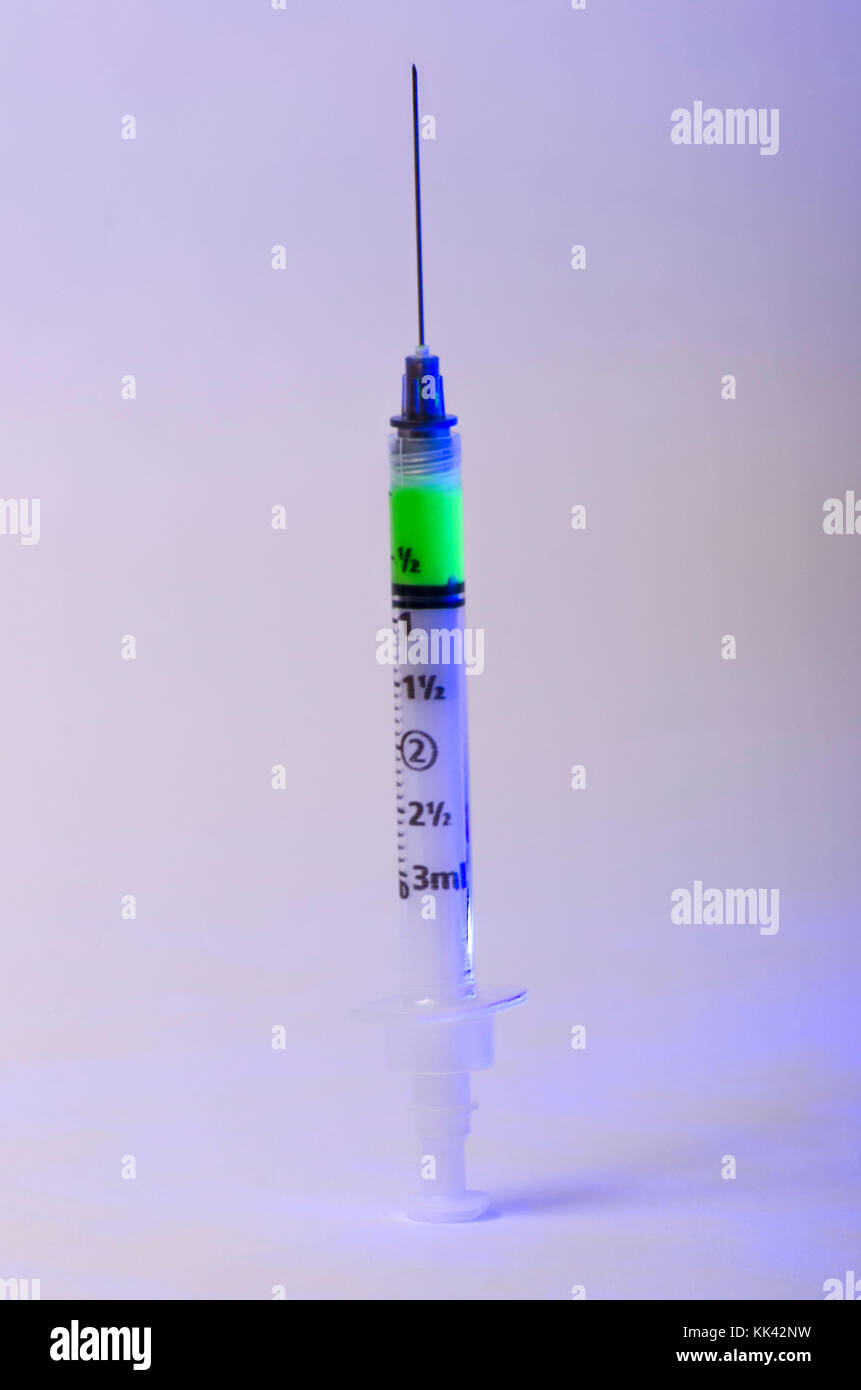 Seringue hypodermique chargé avec une substance verte éclatante impliquant des matières radioactives ou prêt à l'emploi de substances toxiques Banque D'Images