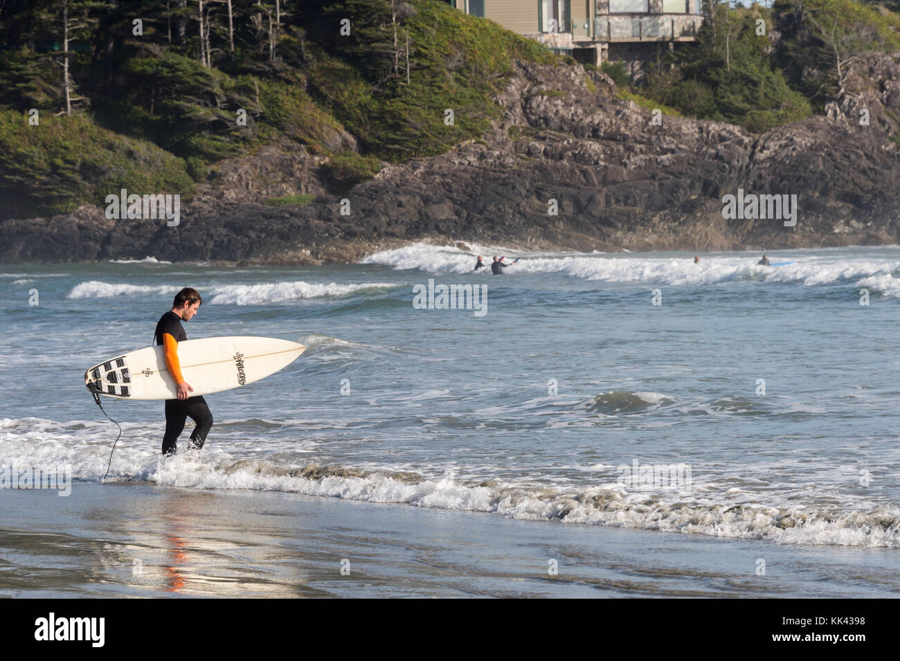 Plage de Chesterman près de Tofino, C.-B., Canada (septembre 2017) - Homme tenant une planche à surf. Banque D'Images