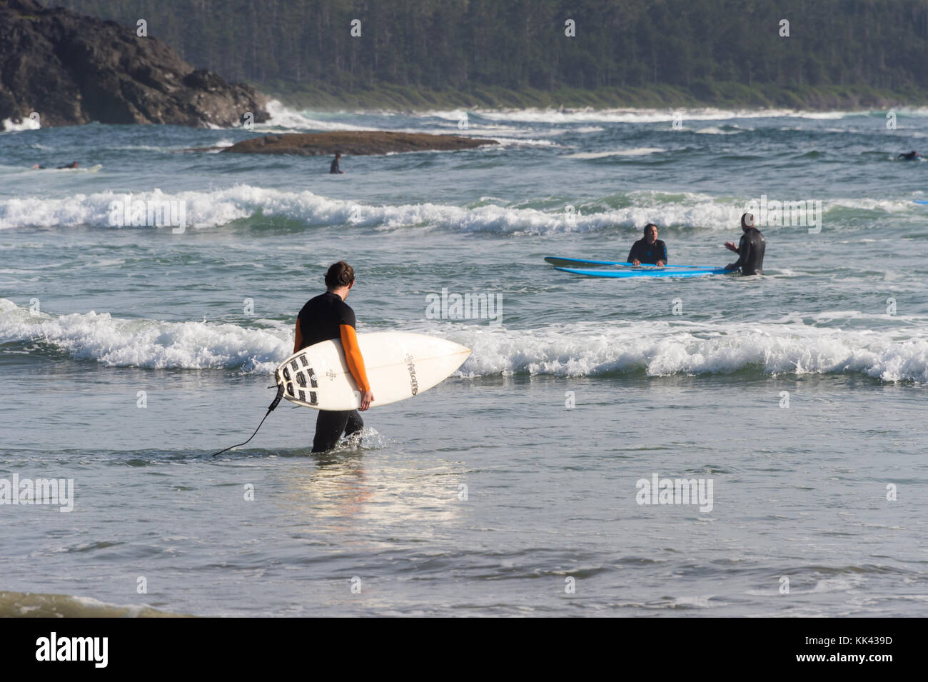 Plage de Chesterman près de Tofino, C.-B., Canada (septembre 2017) - Homme tenant une planche à surf. Banque D'Images