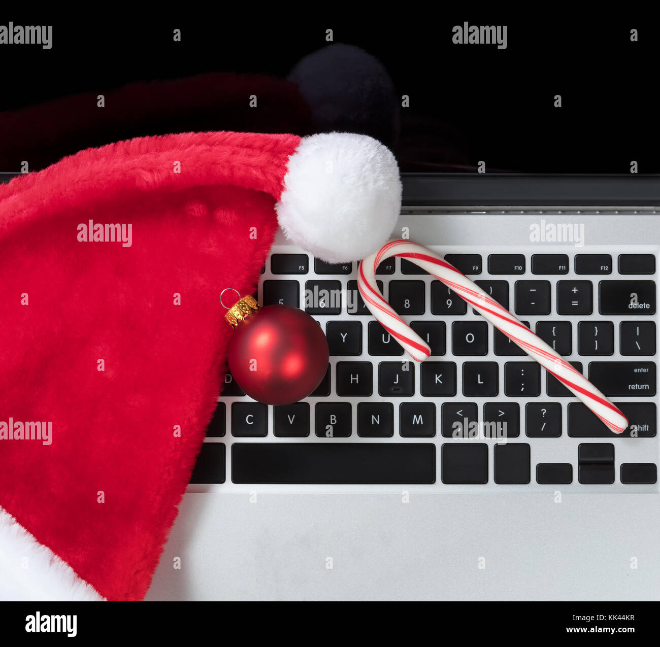 Santa Claus hat et canne de Noël sur le dessus du clavier de l'ordinateur au cours des fêtes de Noël Banque D'Images