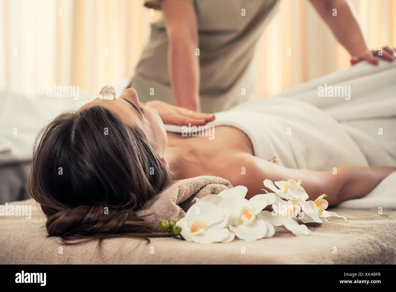 Femme se détendre sous l'effet thérapeutique d'un cristal placé Banque D'Images