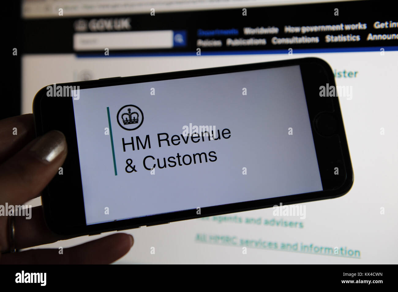 Le site Web de HM Revenue & Customs vu sur un téléphone et un écran d'ordinateur Banque D'Images
