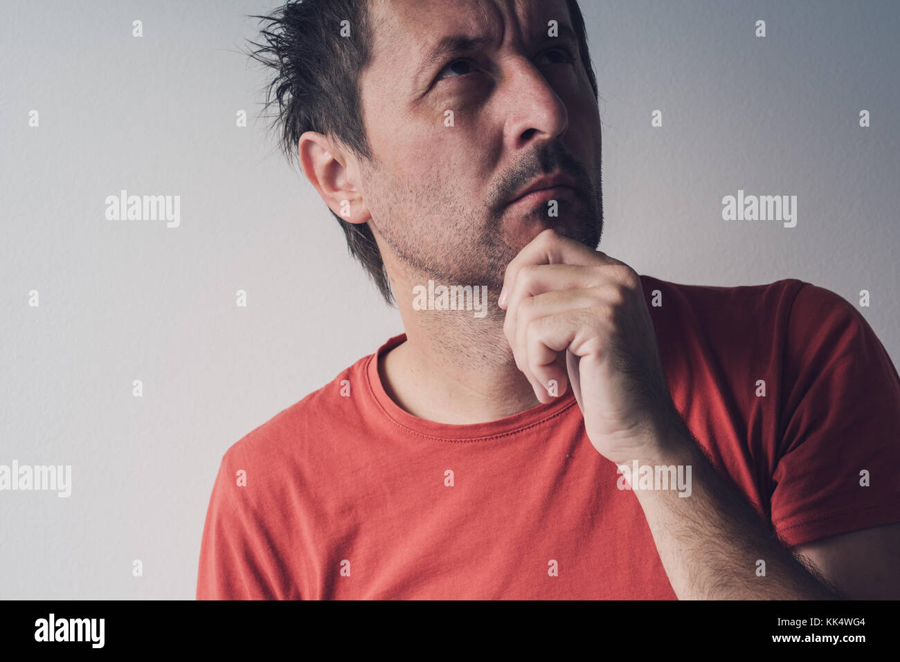 Portrait grave d'adulte caucasian man looking up et de penser, les gens d'expressions du visage Banque D'Images