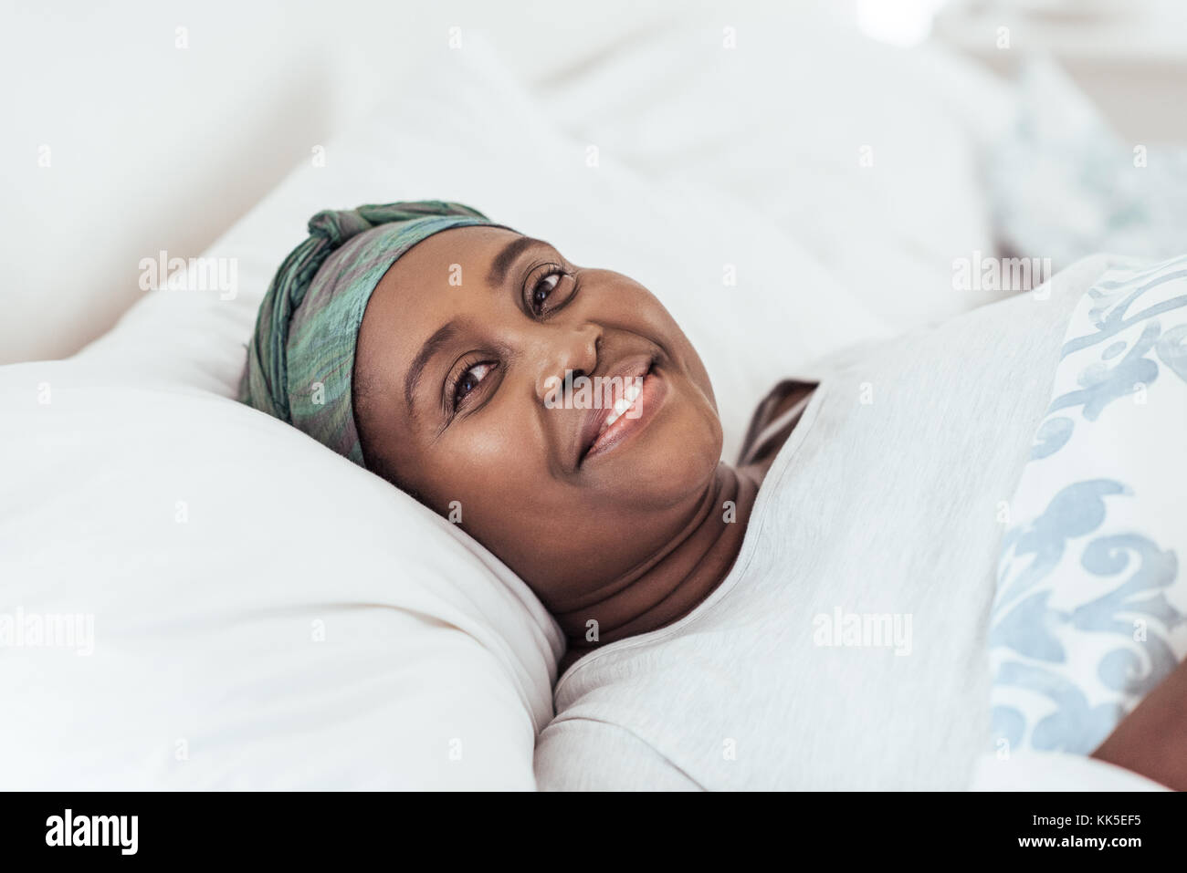 Smiling femme africaine portant un foulard dans mon lit Banque D'Images