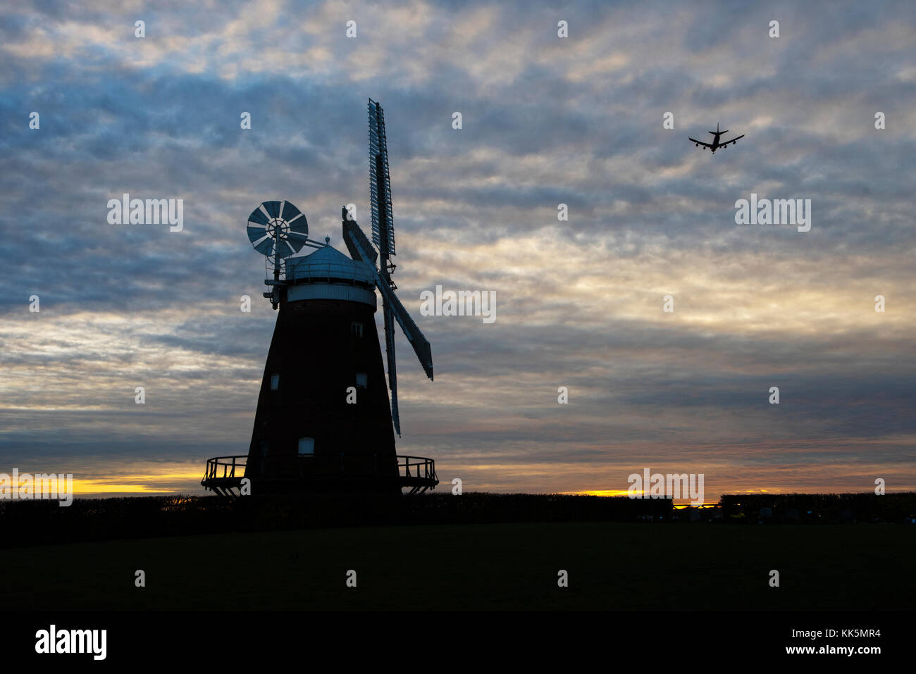 Thaxted moulin au crépuscule avec avion venant en terre à proximité de l'aéroport de Stansted. Essex England UK. Nov 2017 Banque D'Images