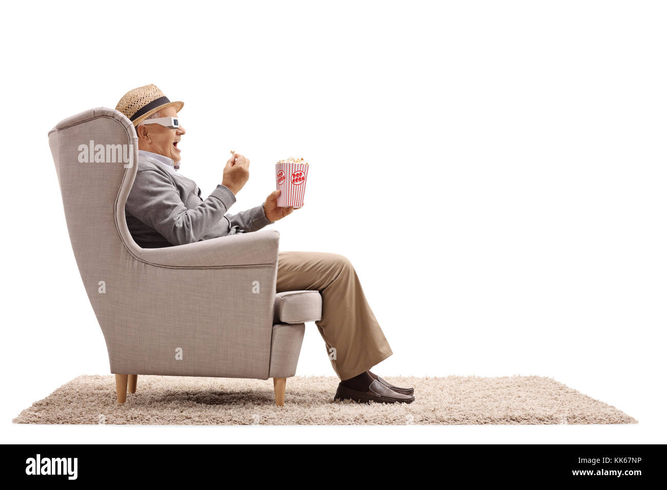 Homme mature avec des lunettes 3-d assise sur un fauteuil et avoir du popcorn isolé sur fond blanc Banque D'Images