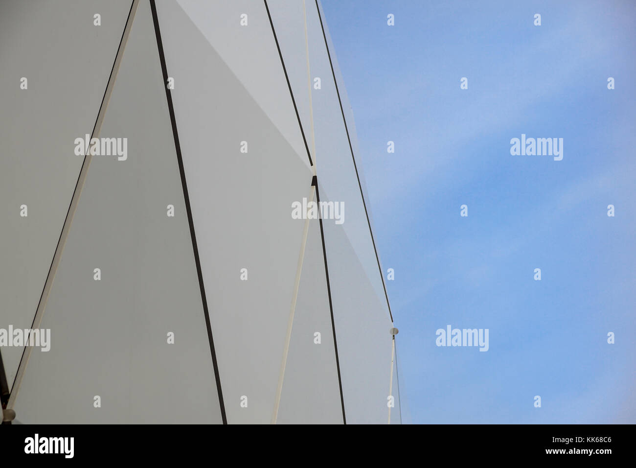 Détail d'une façade circulaire d'un immeuble moderne faite de panneaux sandwich sur fond de ciel bleu. Banque D'Images