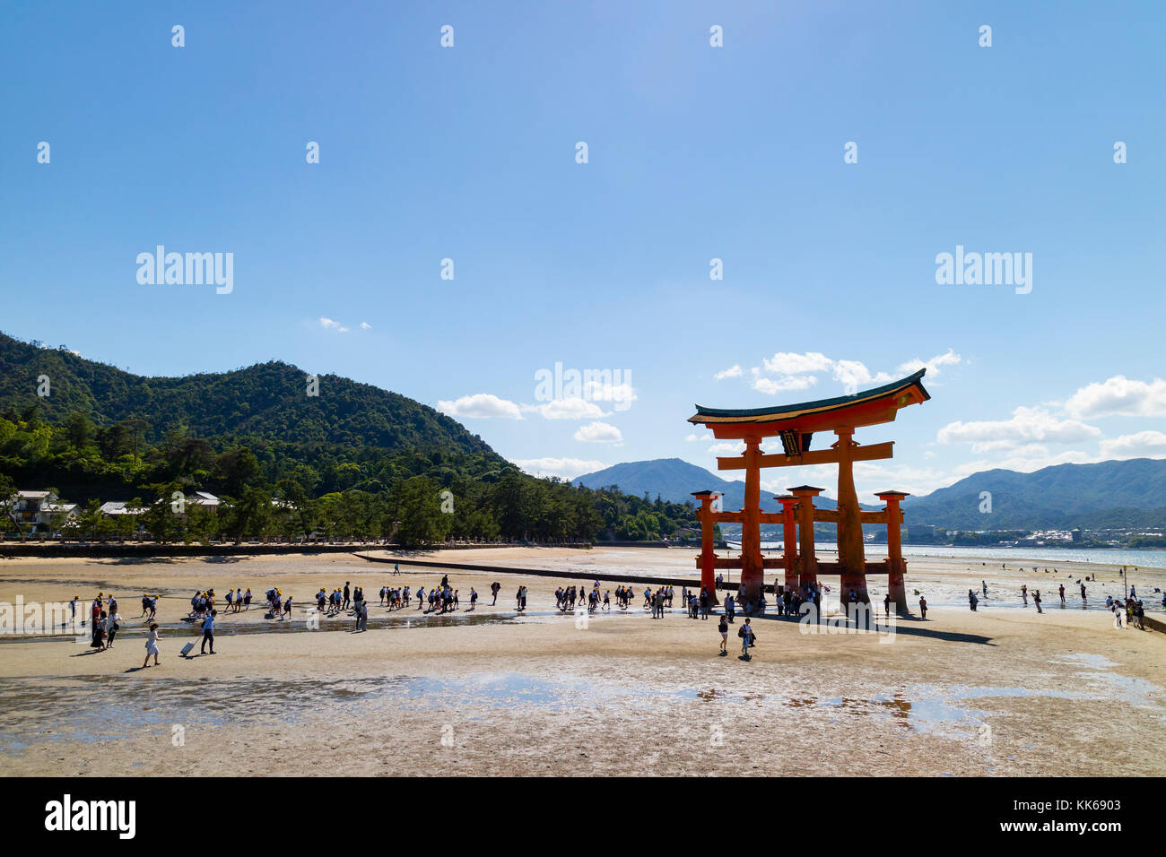 Miyajima - Japon, 26 mai 2017 : rouge torii du sanctuaire d'Itsukushima dans la mer à marée basse près de Miyajima avec beaucoup de touristes la marche sur la san Banque D'Images