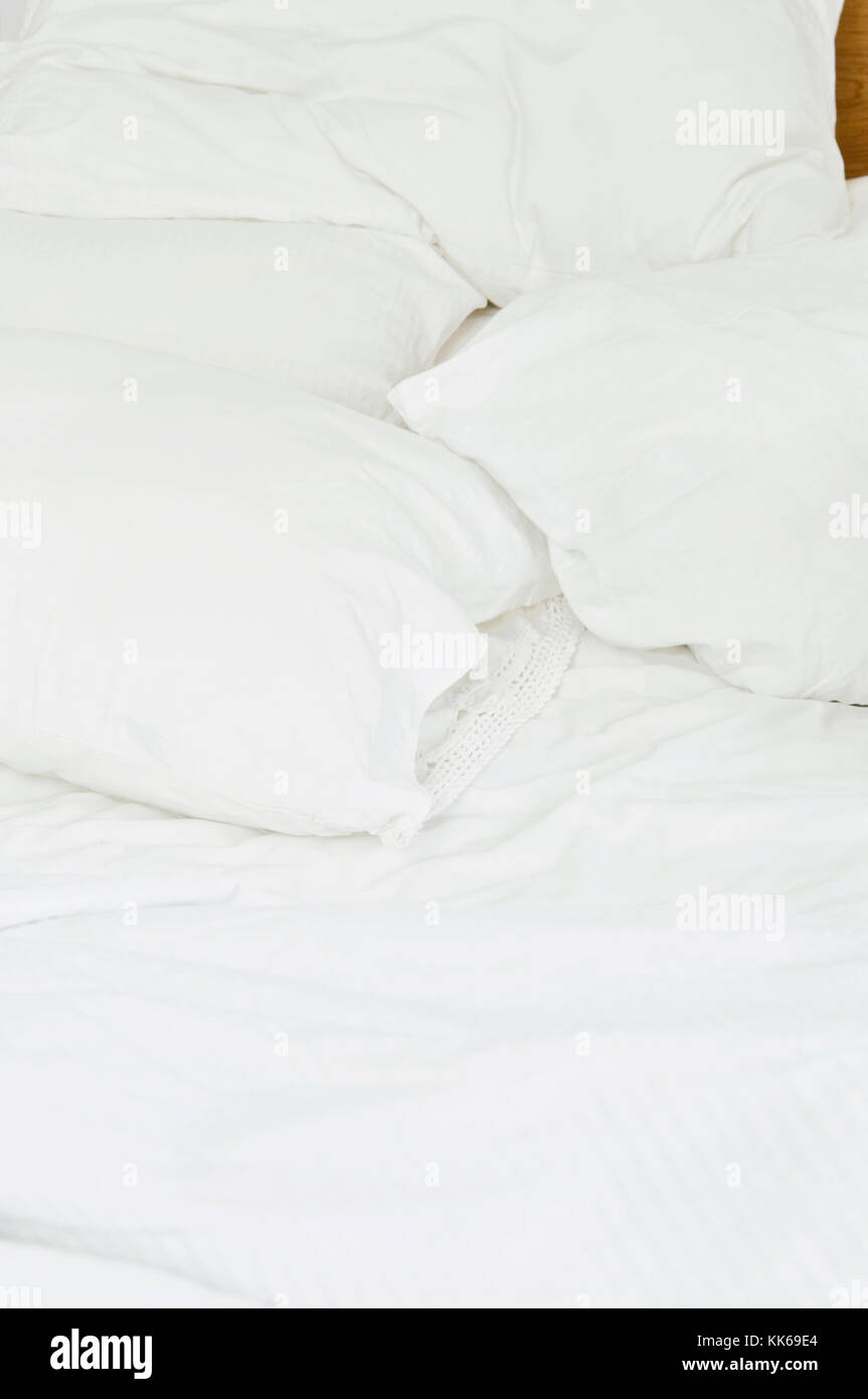 Un lit avec des draps blancs. Banque D'Images