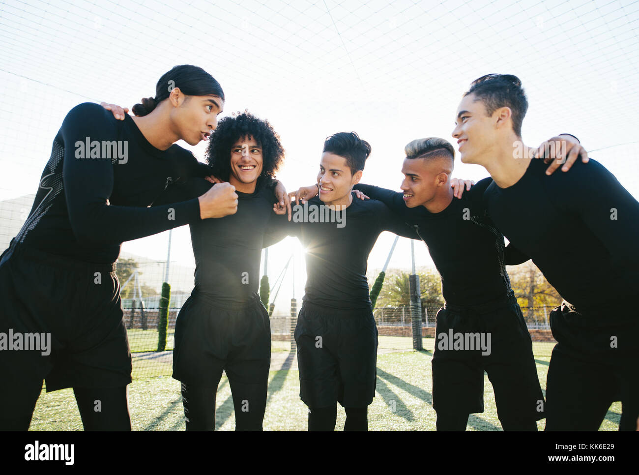 Jeune équipe sportive sur le terrain de football avant le match. joueurs de football discutant de stratégie et motivant et avant le match. Banque D'Images