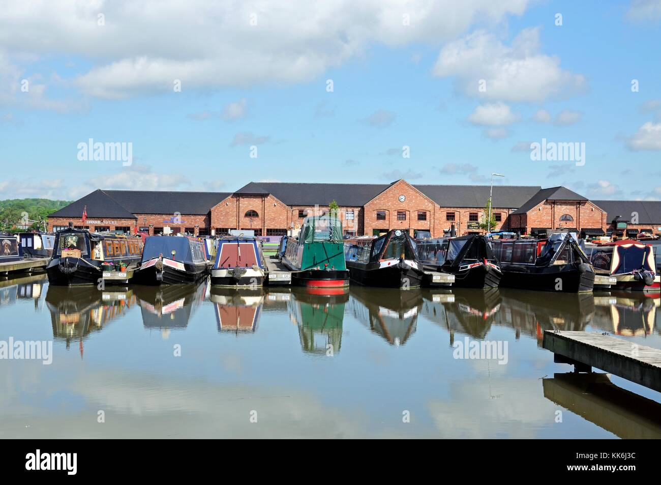 Narrowboats sur leurs amarres dans le bassin du canal, avec des magasins, bars et restaurants à l'arrière, barton marina, barton-under-needwood, Staffordshire, en Banque D'Images