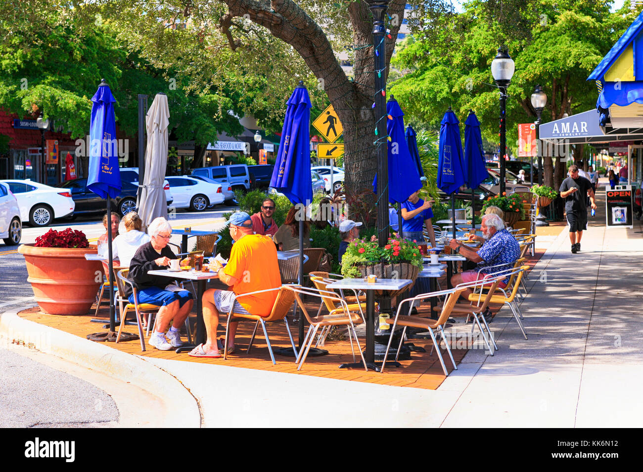 Les gens njoying déjeuner dans un cadre détendu à l'extérieur d'un restaurant dans le centre-ville main Street, Sarasota FL Banque D'Images