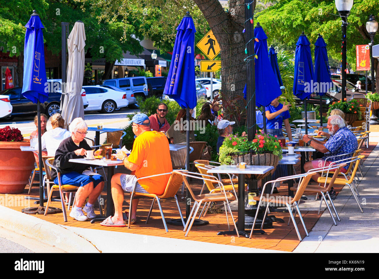 Les gens njoying déjeuner dans un cadre détendu à l'extérieur d'un restaurant dans le centre-ville main Street, Sarasota FL Banque D'Images