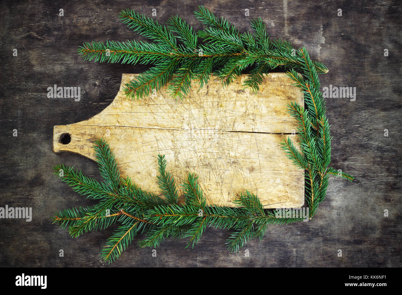 Vieille planche à découper, des branches d'épinette sur un fond de bois cuisine cuisine noël Banque D'Images