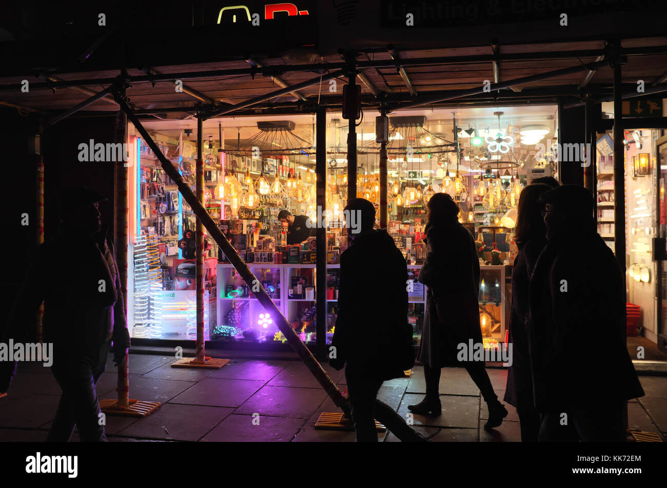 Silhouettes de personnes à pied en face de la boutique d'éclairage sur Old Compton Street à Soho, Londres, Angleterre Banque D'Images