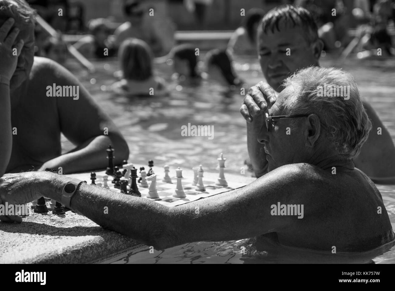De vieux hommes jouant aux échecs dans la piscine thermale extérieure au thermes Széchenyi Budapest., noir et blanc, monochrome Banque D'Images