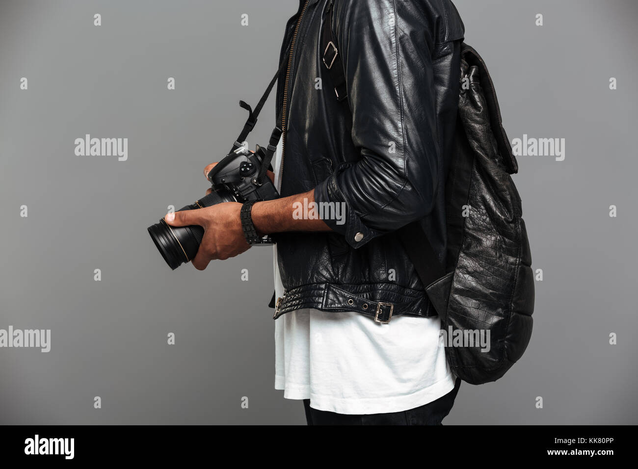 Photo recadrée chic de l'homme africain avec sac à dos, appareil photo, photo holding isolé sur fond gris Banque D'Images
