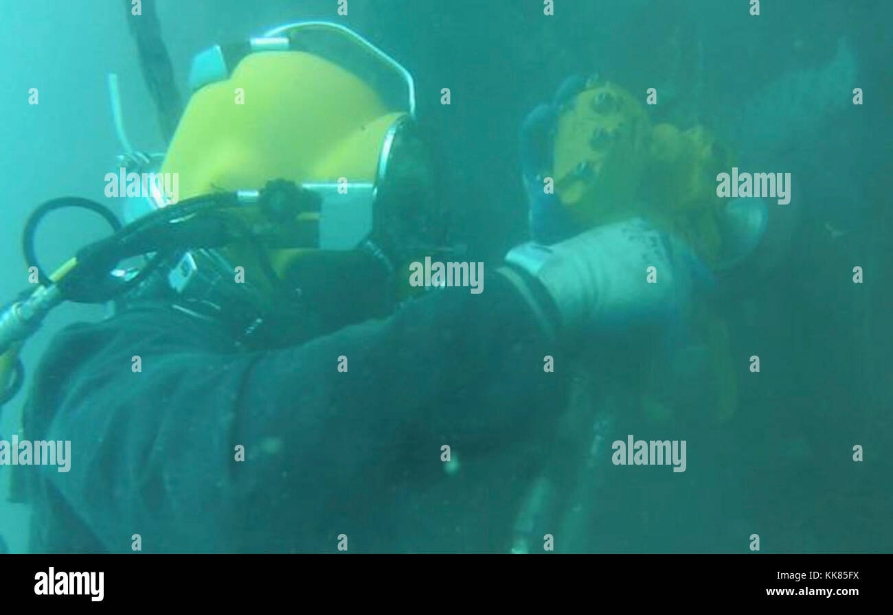 Le constructeur de 3e classe John Williams, un Seabee avec Construction Diving Detachment Alfa (CDDA), Underwater Construction Team 2, nettoie un tas de feuilles à l'aide d'une meuleuse hydraulique sous-marine le 2 novembre 2017. Le CDDA restaure le quai de novembre à la base navale de Guam en remplaçant la protection cathodique. Ce projet prolongera la durée de vie de l’installation en fournissant un espace d’amarrage essentiel pour les biens de la 7e flotte américaine. Le CDDA est sur la dernière étape de son déploiement de six mois, où il effectue des inspections, de l'entretien et des réparations de diverses installations sous-marines et riveraines à l'appui Banque D'Images