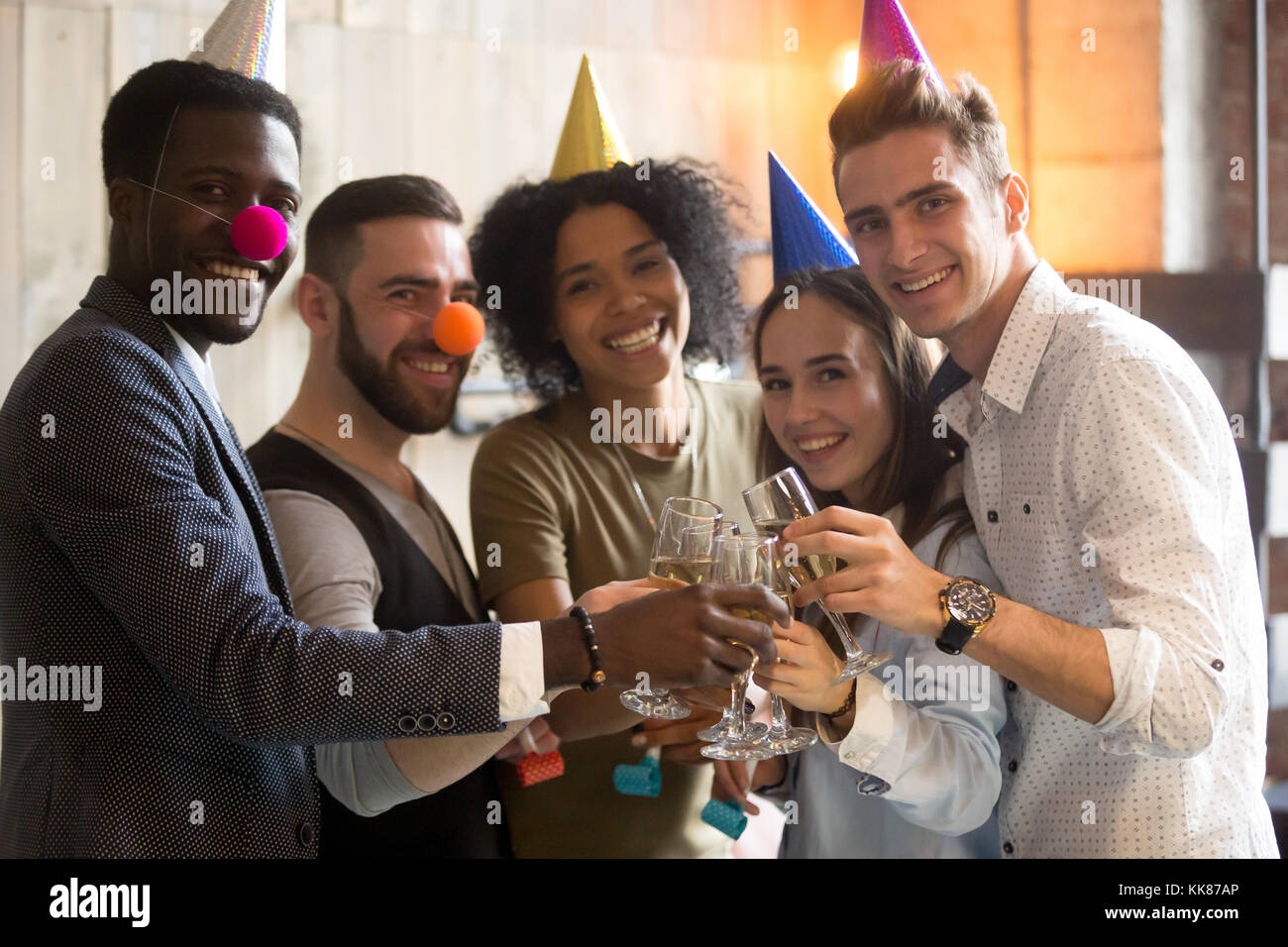 Divers friends clinking champagne glasses looking at camera cel Banque D'Images