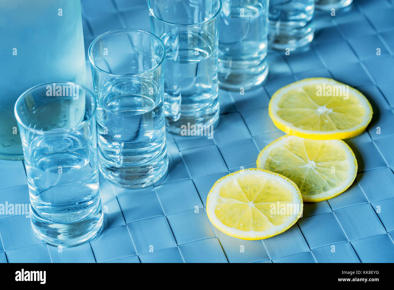 Verre de vodka et citron sur la surface bleue Banque D'Images