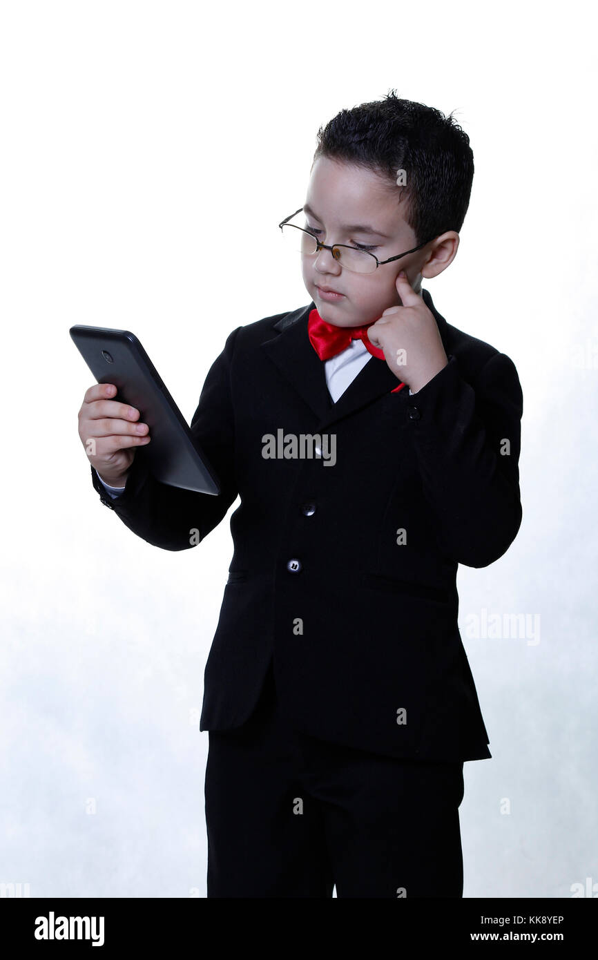 Pensive business boy en vêtements exécutif et porter des lunettes et tablette Banque D'Images