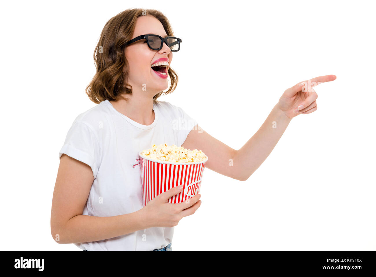 Photo de laughing caucasian woman holding pop corn portant des lunettes 3D isolés. À côté voir le film. Banque D'Images