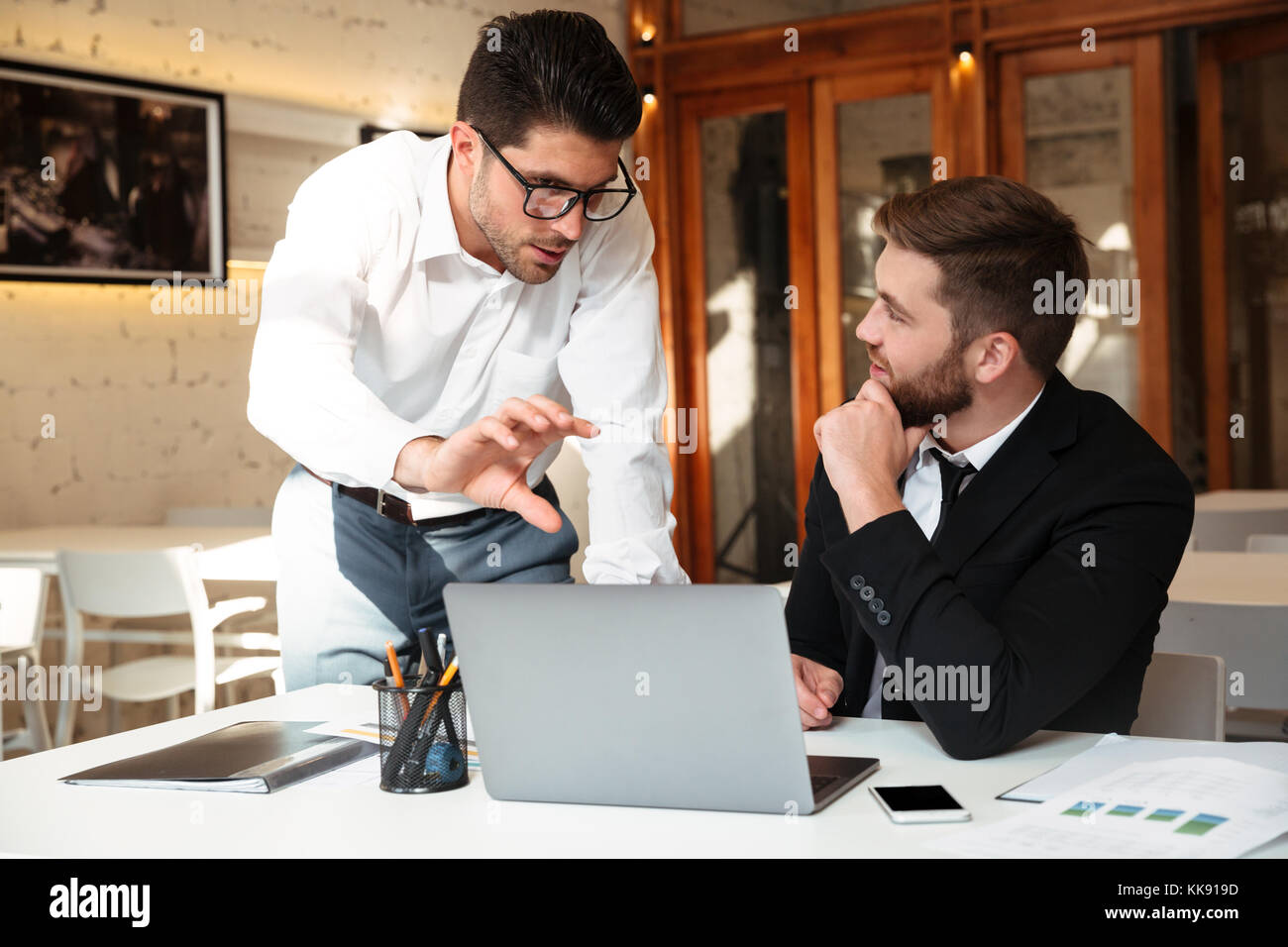 Les objectifs d'affaires de discuter devant les ordinateurs portables à vert au travail Banque D'Images
