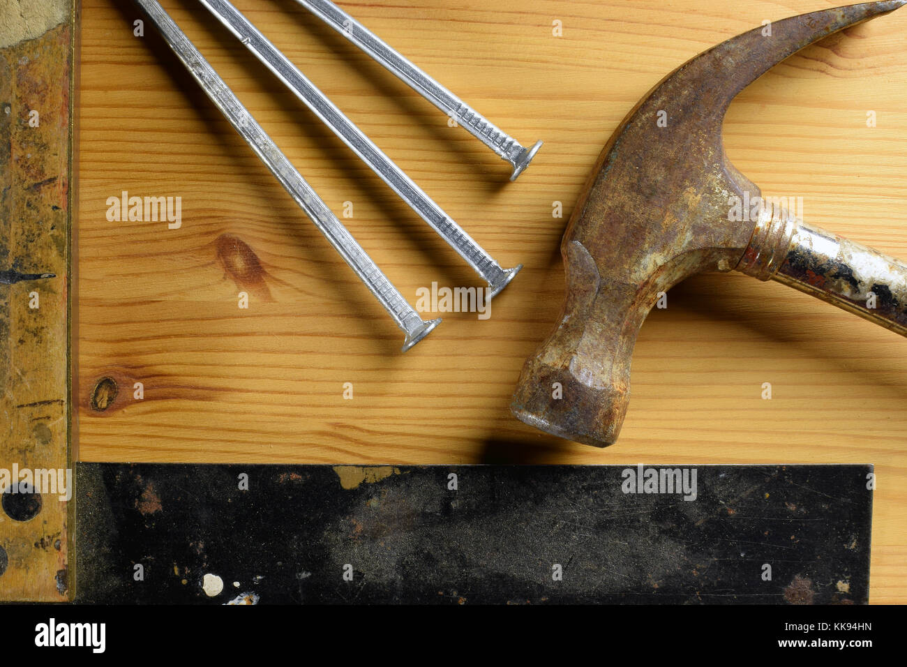 Marteau, clous et carré sur fond de bois. Vue de dessus de l'image outils de bricolage. Banque D'Images