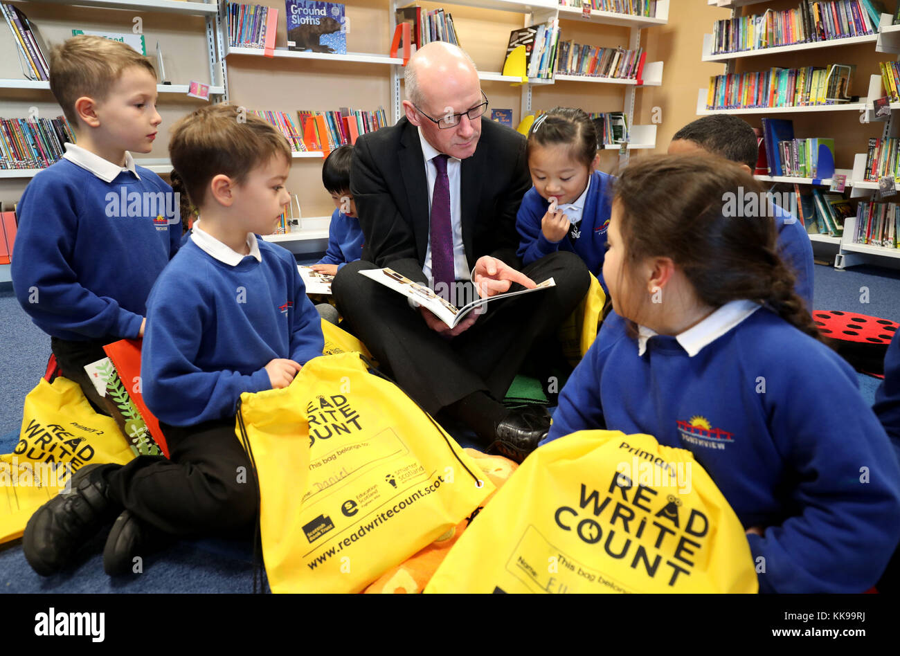 Vice-premier ministre John Swinney célèbre la Semaine du livre de l'Écosse en primaire 2 les enfants explorent leur nouveau lire, écrire, compter des sacs-cadeaux à l'école primaire en Forthview Édimbourg. Banque D'Images