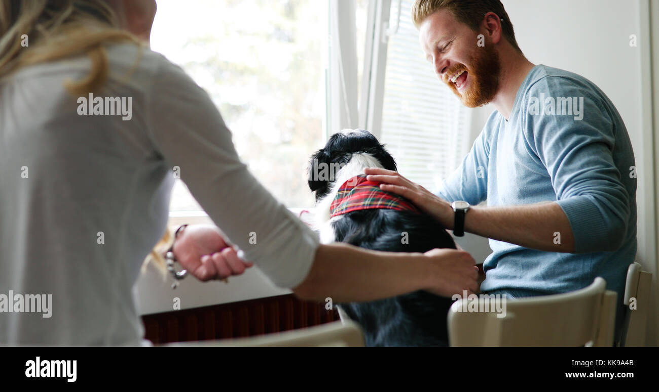 Beau couple relaxing at home et d'aimer leur chien Banque D'Images