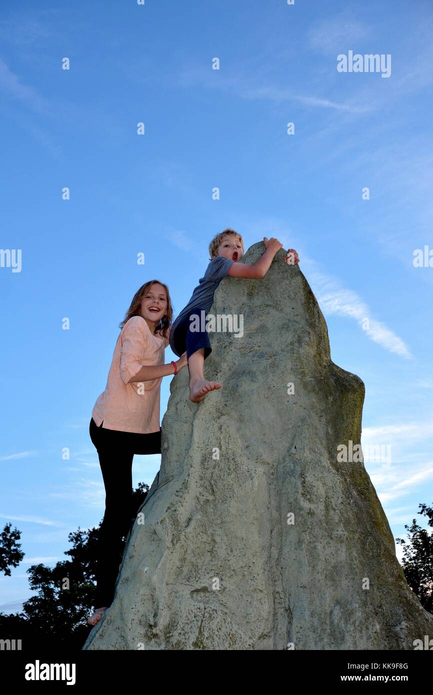 Deux enfants à grimper, garçon détient sur au point d'un kletter - rock, directement sous lui de fille Banque D'Images