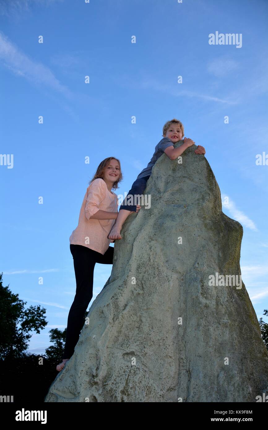 Deux enfants à grimper, garçon détient sur au point d'un kletter - rock, directement sous lui de fille Banque D'Images