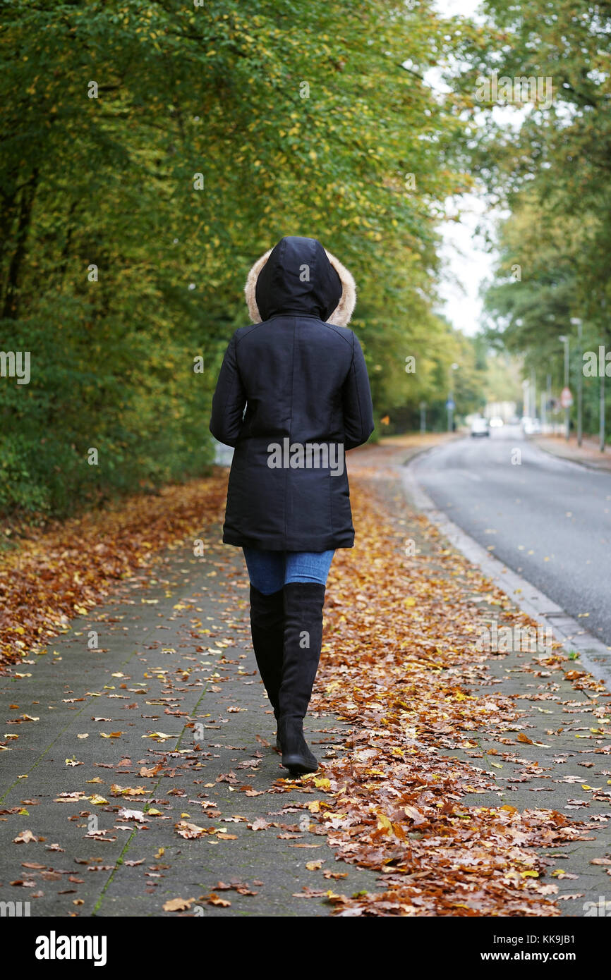 Méconnaissable femme portant des bottes manteau d'hiver et marche dans la rue Banque D'Images