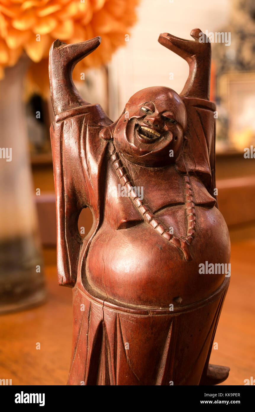 Old Wood Carving of a Buddhist figure avec les bras tendus et une expression de bonheur Banque D'Images