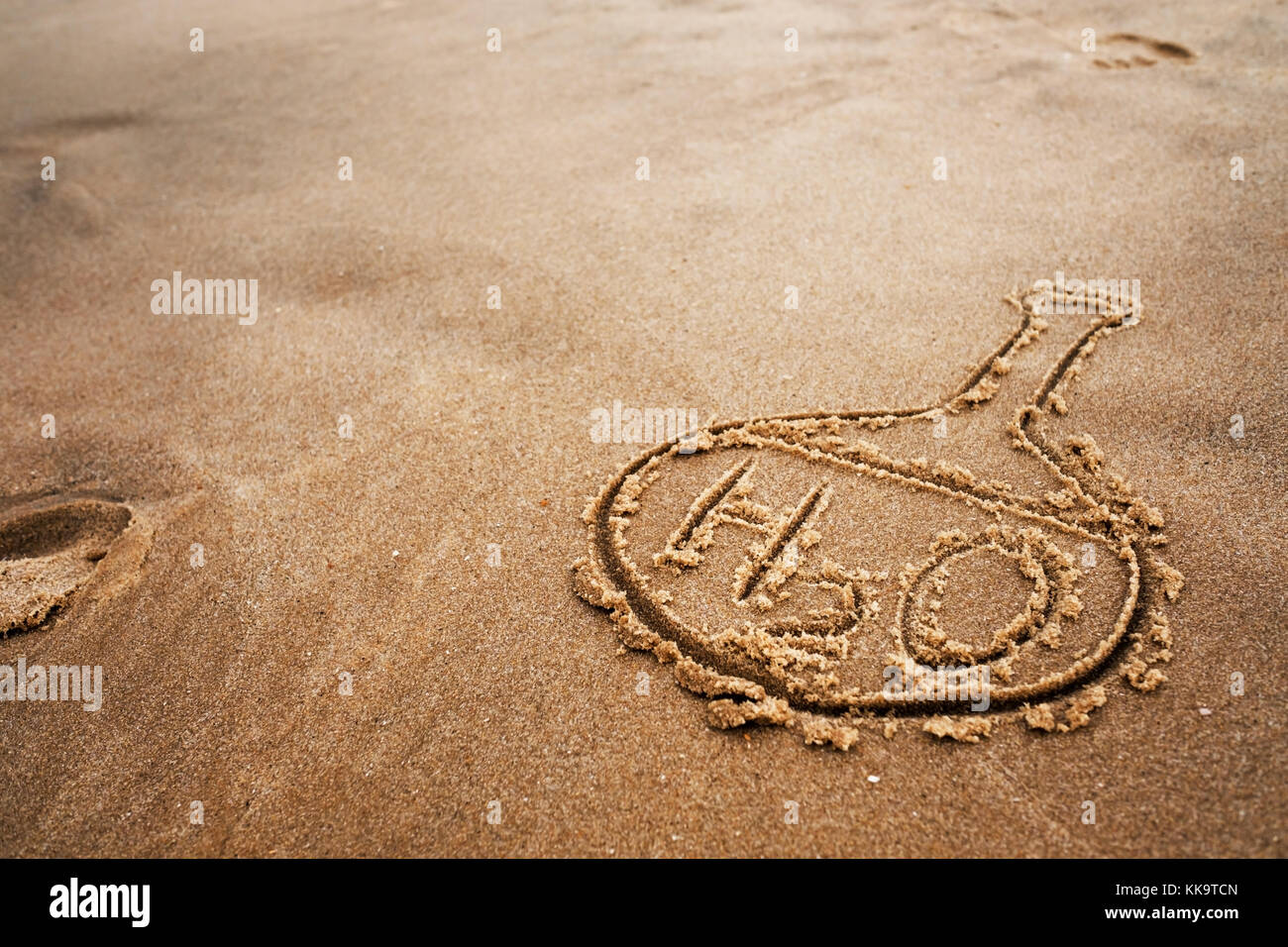 Ballon peint et la formule chimique de l'eau sur le sable. La qualité de l'eau sur la plage et l'océan. Banque D'Images
