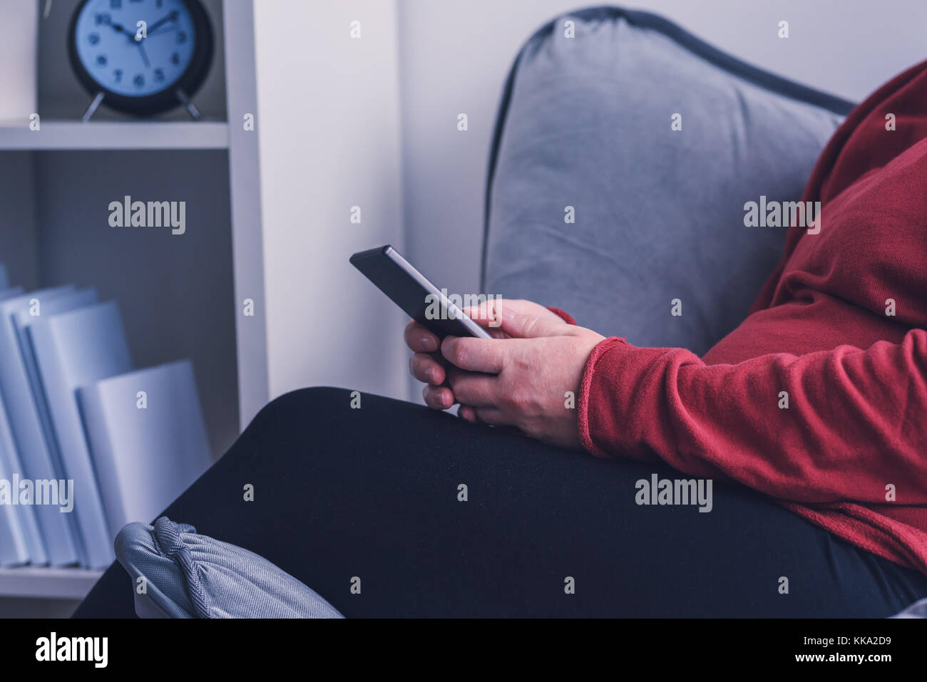 Femme enceinte détendue à l'aide de smart phone app mobile et à s'informer sur la grossesse et la maternité Banque D'Images