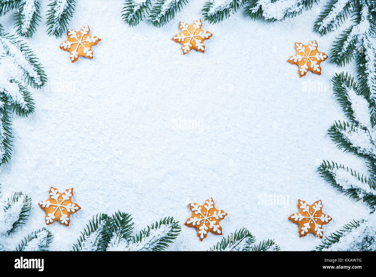 Noël arrière-plan avec gingerbread cookies avec de la neige et de l'espace libre des branches d'arbre. Banque D'Images