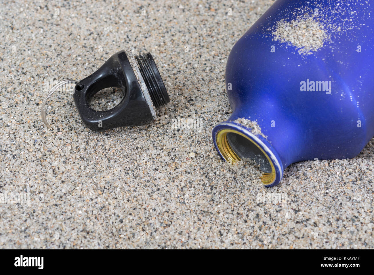 Bouteille d'eau vide sur fond de sable - métaphore de l'exécution hors de l'eau, la survie du désert, les dangers de voyages dans le désert. Banque D'Images